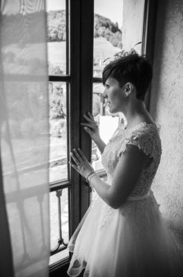 photo de la mariée en noir et blanc devant la fenêtre